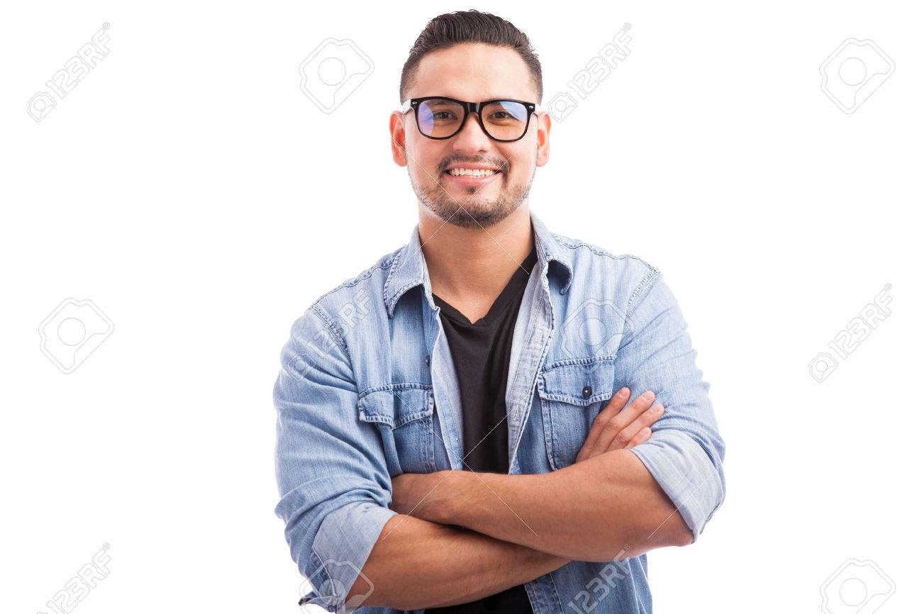 A man wearing glasses smiling happily while crossing his arms